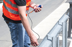 Il misuratore di spessore per rivestimenti mentre sta controllando il guard rail.