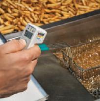Misuratore di temperatura senza contatto in alimenti mentre misura la temperatura della vetrina.