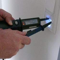 Il tester di tensione PCE-TT1 mentre verifica una presa con illuminazione del punto di misurazione